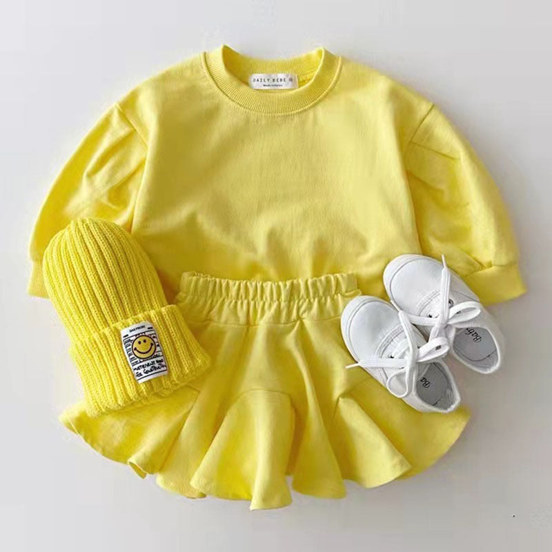 Soft Baby Outfit Set in candy color featuring a yellow pullover, skirt, hat, and shoes.